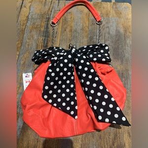 Claire’s orange purse with black and white polka dot bow tie